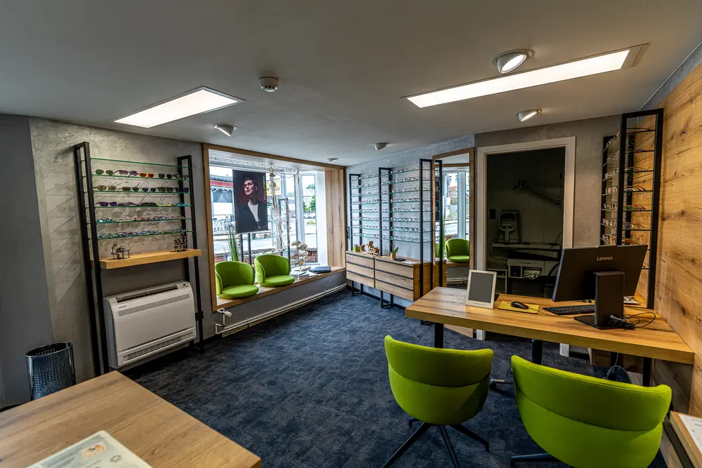 Verkaufsraum von Optik Beer mit Beratungsplatz und Brillenwänden